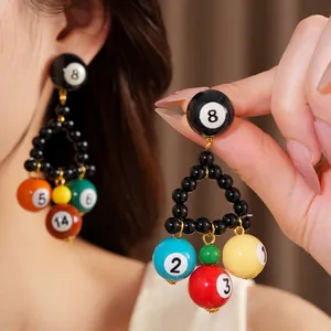 Gros plan de boucles d'oreilles pendantes en résine boules de billard avec chiffres