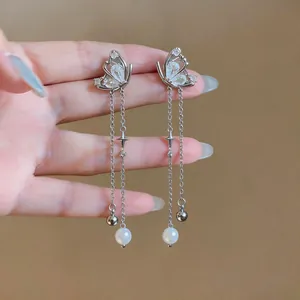 Detailed shot of elegant butterfly stud earrings with shiny zircon stones and pearl tassels