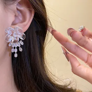 Dettaglio ravvicinato di orecchini a fiore in resina con nappe in zircone lucido