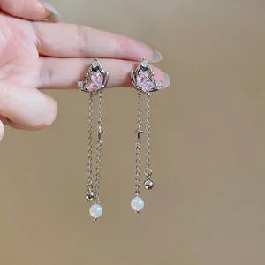 Detail of pink zircon butterfly tassel earrings with elegant white pearls