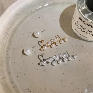 Close-up of elegant French vintage asymmetric pearl earrings in gold and silver