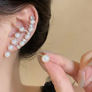 Detailed close-up of elegant French retro pearl earrings with zircon accents on ear