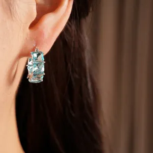 Eleganti orecchini a cerchio in argento con zirconi blu cielo quadrati sul modello