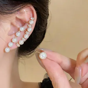 Close-up of elegant French retro asymmetrical pearl and zircon ear crawler and stud set
