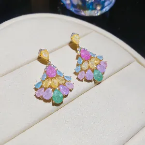 Gros plan de boucles d'oreilles en zircon coloré en forme d'éventail sur boîte à bijoux