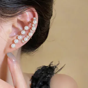 Close-up of an elegant French vintage asymmetrical pearl and crystal ear cuff on a model's ear.