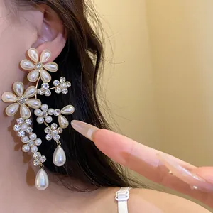 Detailed view of vintage floral earrings with pearls and rhinestones on ear.