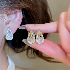 Close-up of sparkling 18k gold plated water drop clip-on earrings with cubic zirconia.