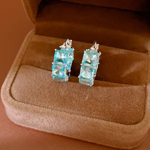 Dettaglio squisito di orecchini a cerchio in zirconia blu in una scatola di velluto