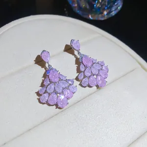 Gros plan détaillé de boucles d'oreilles en zircon rose en forme de goutte d'eau de luxe