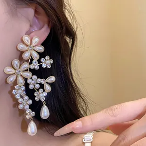 Close-up detail of vintage floral drop earrings with pearls and rhinestones on ear