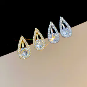 Close-up of teardrop zircon clip-on earrings in gold and silver finish with sparkling halo
