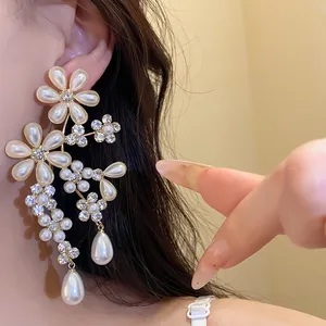 Close-up detail of vintage flower dangle earrings with pearls and shiny rhinestones