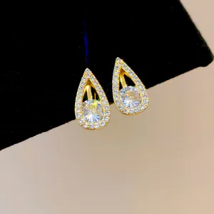 Detailed macro view of 18k gold-plated teardrop clip earrings with clear sparkling zirconia stones.