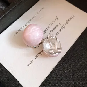Detailed view of pink oval enamel earrings showing front pattern and back clip mechanism