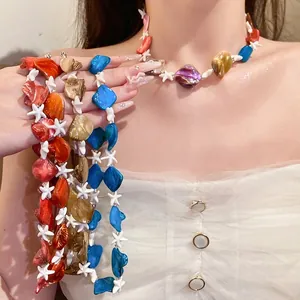 Collezione di collane con perline di conchiglia e stella marina indossate da un modello