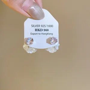 Detailed macro view of 925 silver flower stud earrings presented on a white jewelry display card.