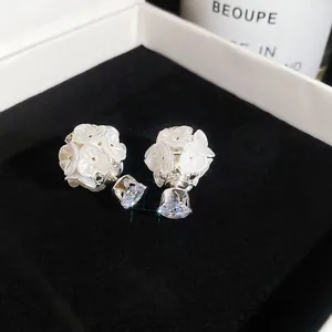 Close-up of elegant flower earrings with pearl finish and sparkling crystals in gift box
