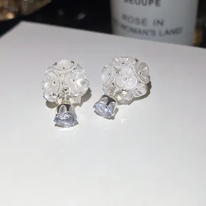 Close-up of white cluster flower earrings with a sparkling round cubic zirconia drop.