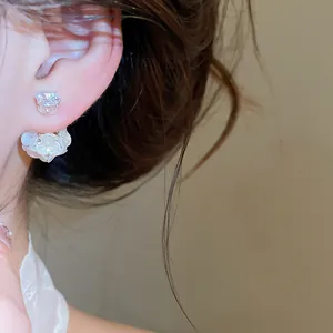 Macro detail of elegant white flower and crystal stud earring on ear, sweet Korean style