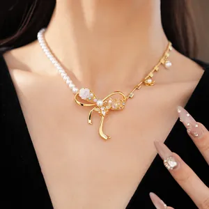 Detailed view of bee and bow pendant necklace with pearls and zircon flower accents.