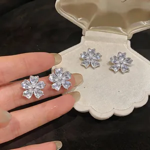 Detailed view of silver flower stud earrings set with sparkling zircons