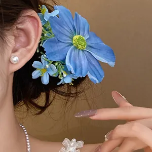 Élégante barrette à cheveux fleur en tissu bleu présentée sur un mannequin avec perles