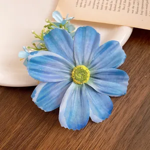 Vue détaillée de la pince à cheveux fleur en tissu bleu avec texture de pétale réaliste.