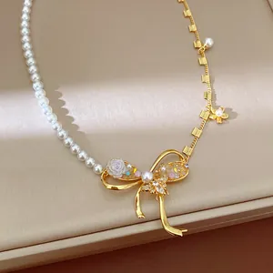 Close-up of elegant gold-plated bowknot necklace with pearls and floral details