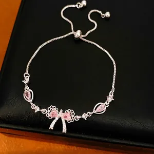 Elegante bracciale regolabile in argento con fiocco in zircone rosa e ciondoli a goccia.