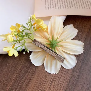 Vue détaillée montrant la pince crocodile en métal de l'accessoire de cheveux fleur en tissu