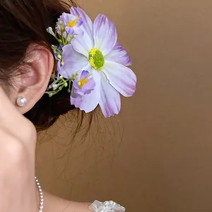 Gros plan d'une pince à cheveux en fleur de tissu violette portée sur le côté avec détails