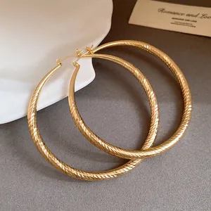 Gros plan détaillé de boucles d'oreilles créoles dorées avec finition facettée