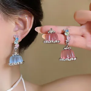 Close-up view of delicate zircon pudding pendant earrings featuring colorful resin charms.