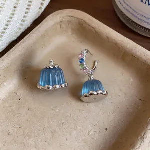 Detailed macro view of exquisite blue resin pudding earrings with colorful zircon stones