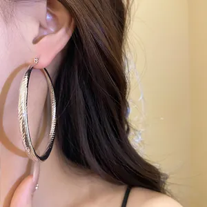 Vue détaillée de grandes créoles argentées facettées pour un look vintage et élégant.