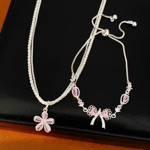 Vista dettagliata di collana e bracciale in argento con fiori e fiocchi in zircone rosa