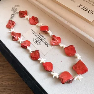 Dettaglio della collana stile vacanza con perline rosse e stelle marine bianche