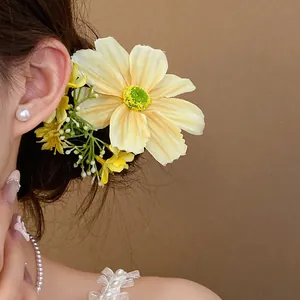 Vue détaillée d'une pince à cheveux fleur en tissu jaune de style forêt douce