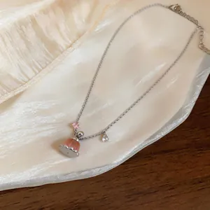 Close-up of a resin pudding pendant necklace with zircon charms on silk fabric.