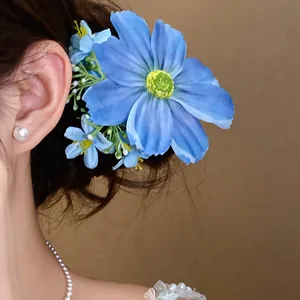 Gros plan détaillé d'une pince à cheveux fleur en tissu bleu clair sur un mannequin