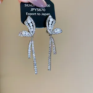 Close-up of elegant butterfly clip-on earrings with shimmering zircon and pearl details