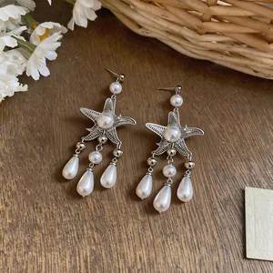 Boucles d'oreilles étoile de mer style français avec perles gouttes d'eau sur bois.