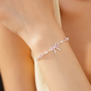 Dettaglio di un elegante braccialetto in argento a fiocco con zirconi rosa al polso
