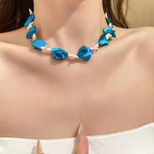 Primo piano di una collana da spiaggia con perle di conchiglia blu e stelle marine