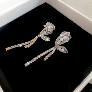 Elegant silver butterfly ear clips featuring shimmering zircons and round pearls in a box
