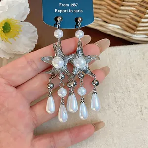 Détail des boucles d'oreilles étoile de mer de style français avec perles et glands