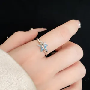 Vista dettagliata di un elegante anello argentato con motivo a stella marina blu e zircone