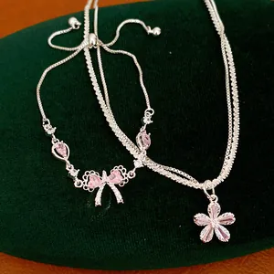 Vista macro dettagliata di eleganti ciondoli a fiocco e fiore in argento con zirconi rosa.