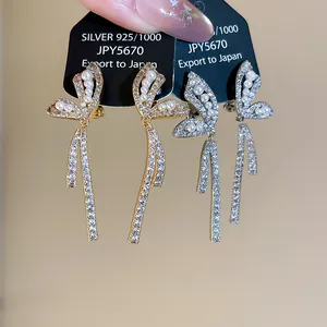 Macro detail of elegant 18k gold plated butterfly clip-on earrings with zircon pearls
